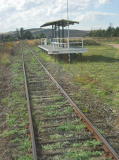 Bunyan station, with tracks on either side of the platform. Other remnants of the railway can be found amongst the weeds.
