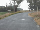 A slightly uneven surface marked with puddles indicates where the rail would have crossed this road entering Roslyn on the Crookwell railway line.