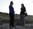Denise and Shami in conversation on top of a sand dune at Peka Peka beach.