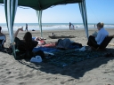 Mauricio, Snaiet, Denise, Haydn, and Jann lie under a gazebo on Peka Peka beach.