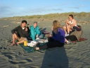 Mauricio, Jann, Denise, Paul, and Snaiet each fish 'n' chips on Peka Peka beach.
