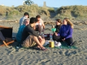Haydn, Jann, Mauricio, Paul, Snaiet, and Denise eat fish 'n' chips on Peka Peka beach.