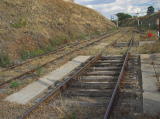 A concrete pad at the southern end of Cooma platform, with sleepers bolted onto it.