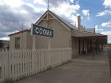 Looking northwest from Cooma platform up to the station building and signage.