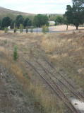 A closer look at the siding to the saleyards. The siding has been abandoned for some time, and the track has been lifted across the road.