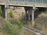 A look underneath the Monaro Highway bridge to the southwest, the track snakes down through a cutting towards Cooma Creek.