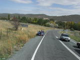 The train goes over the crossing with Old Cooma Road. The crossing is guarded with stop signs only.