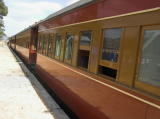 The carriages at the platform of Royalla station. In the reflection of the carriages can be seen the picnic and the station sheds.